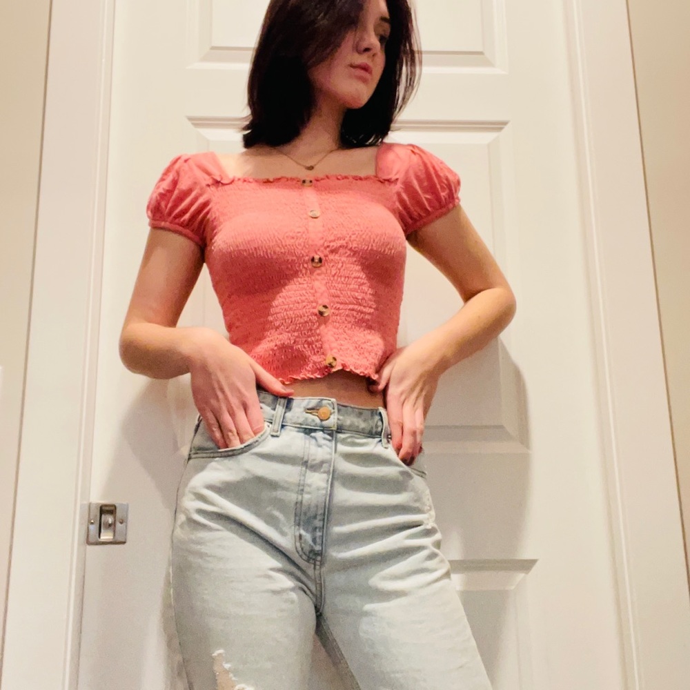 A pink crop top. Size medium, brand Mudd. Never worn